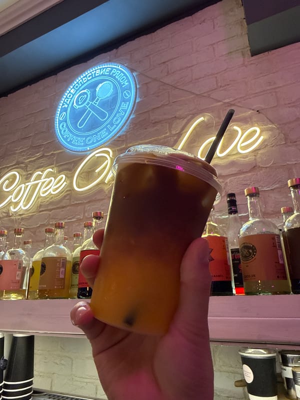 Person holds layered iced coffee drink in Khimki