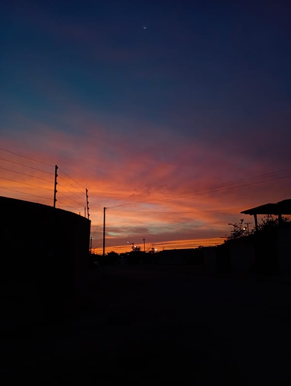 Vibrant sunset with crescent moon observed over Juan Griego, Venezuela