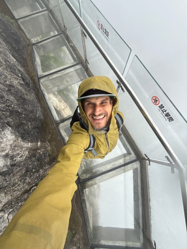 Tourist documents foggy morning visit to glass walkway in China