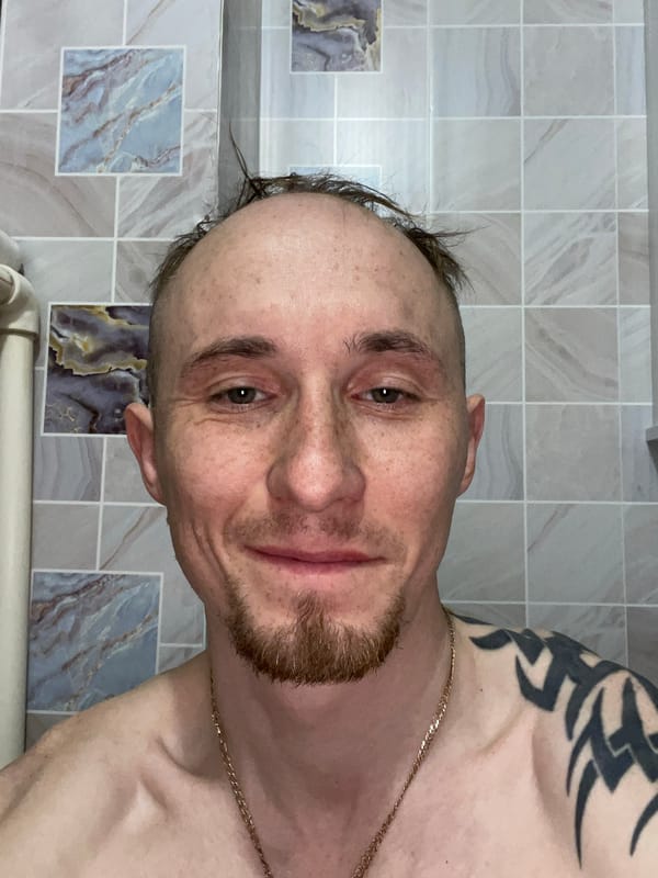 Man photographed shirtless against tiled wall in Devyatovo