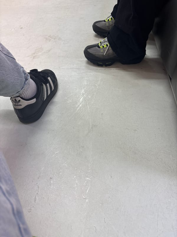 Two pairs of feet observed on Manchester floor