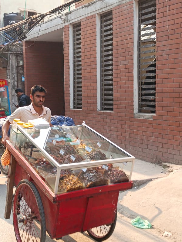 Street vendor pushes sweet cart through sunny Dhaka streets