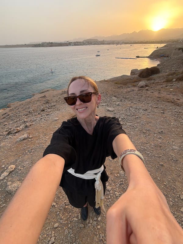 Man photographs sunset from cliff overlooking Red Sea in Egypt
