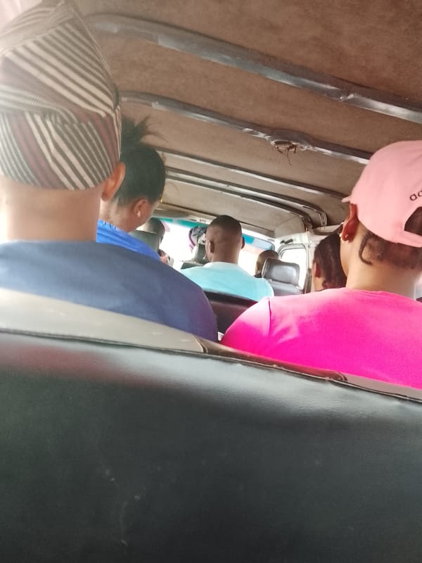 Vehicle interior shows five seated passengers from behind