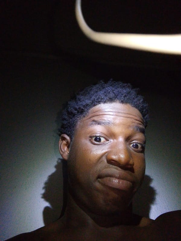 Person photographed making playful faces in dramatic lighting