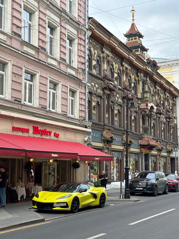Yellow Corvette parked outside Moscow restaurant near East Asian-style building