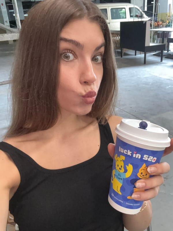 Woman poses with Luckin Coffee cup during studio shoot