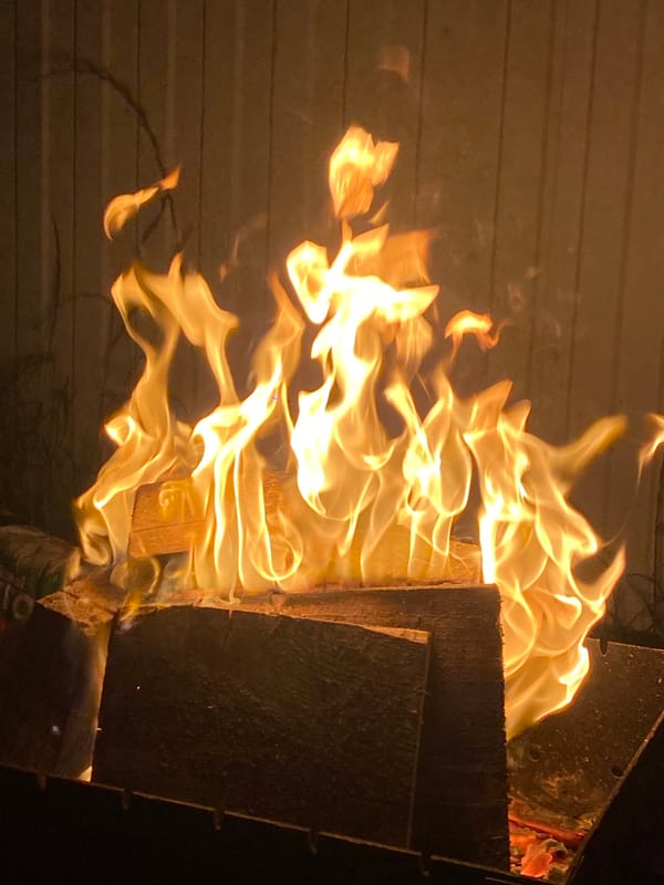 Bonfire burning on stacked logs at night