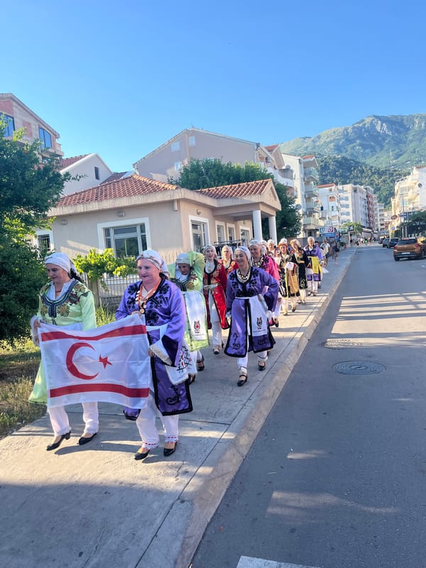 Afternoon street life in a mountain-backed city with traditional parade