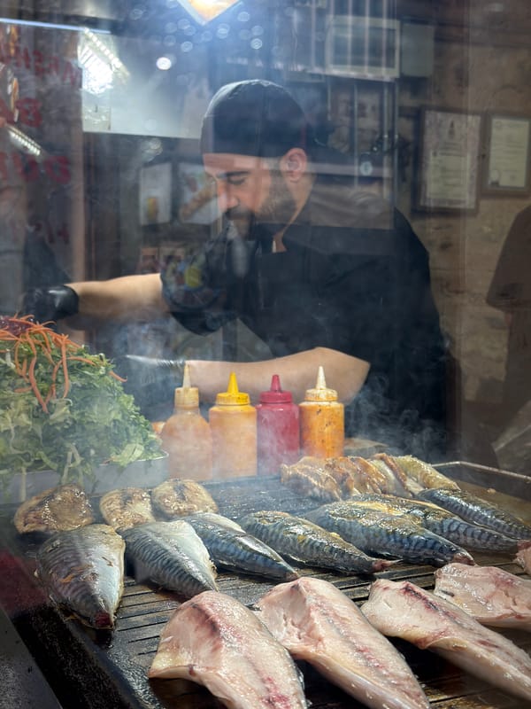 Fish vendor prepares meal at glass stall in Beyoğlu
