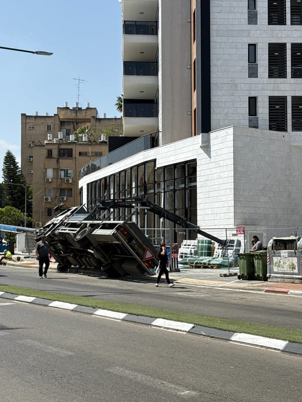 Truck overturns on Petah Tikva street, draws onlookers