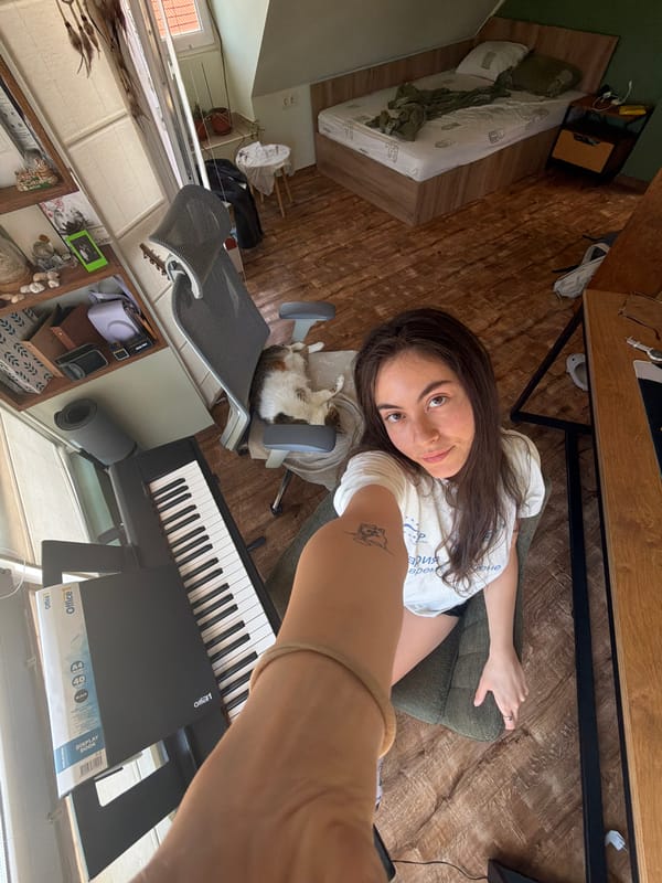 Woman takes selfie as cat naps nearby indoors