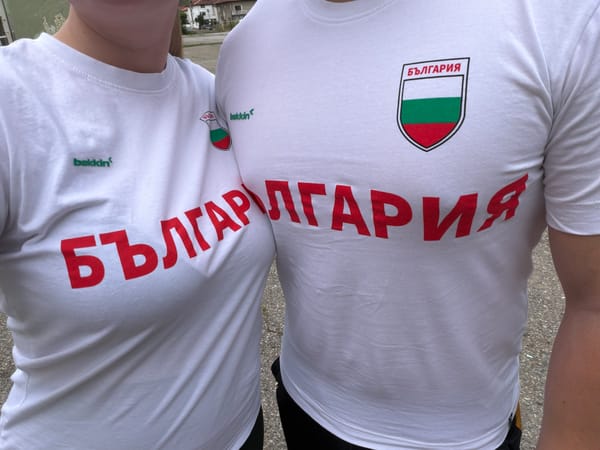 Two people in white shirts stand together outdoors