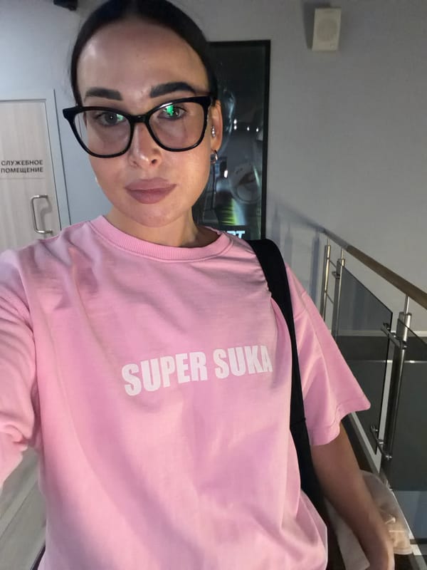 Hallway selfie in Saint Petersburg, pink tee, orange phone