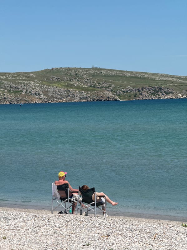 Two people relax on pebble beach in Ukraine