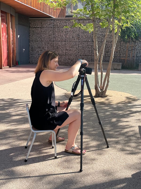 Woman sets up camera equipment for photography session in French park