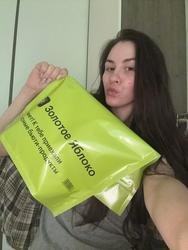 Woman carries Golden Apple beauty store bags in Saint Petersburg