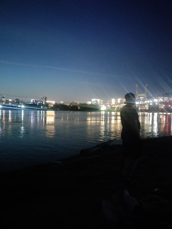 Novosibirsk skyline glows across the water at night