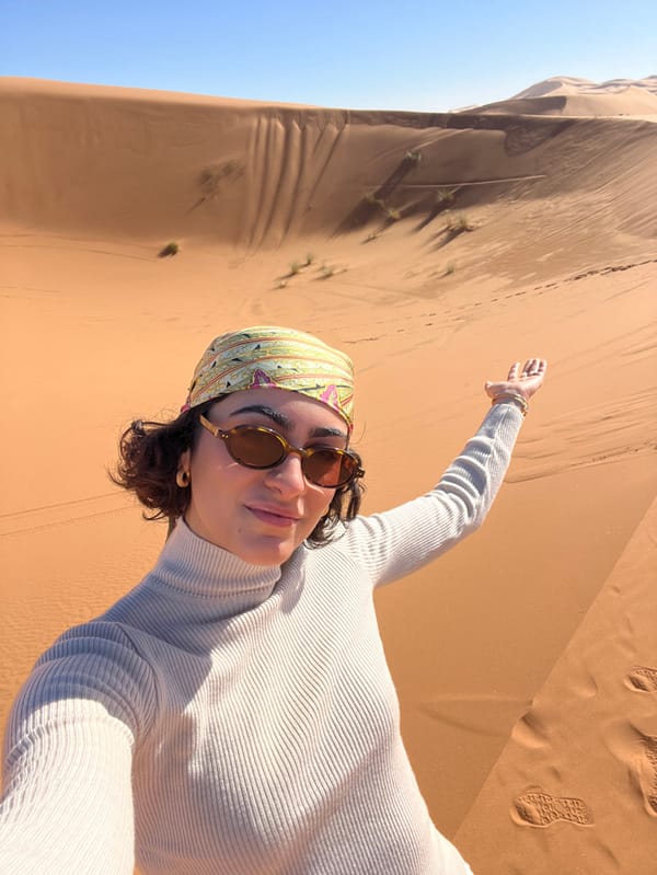 Woman photographs desert journey across Moroccan sand dunes near Rissani