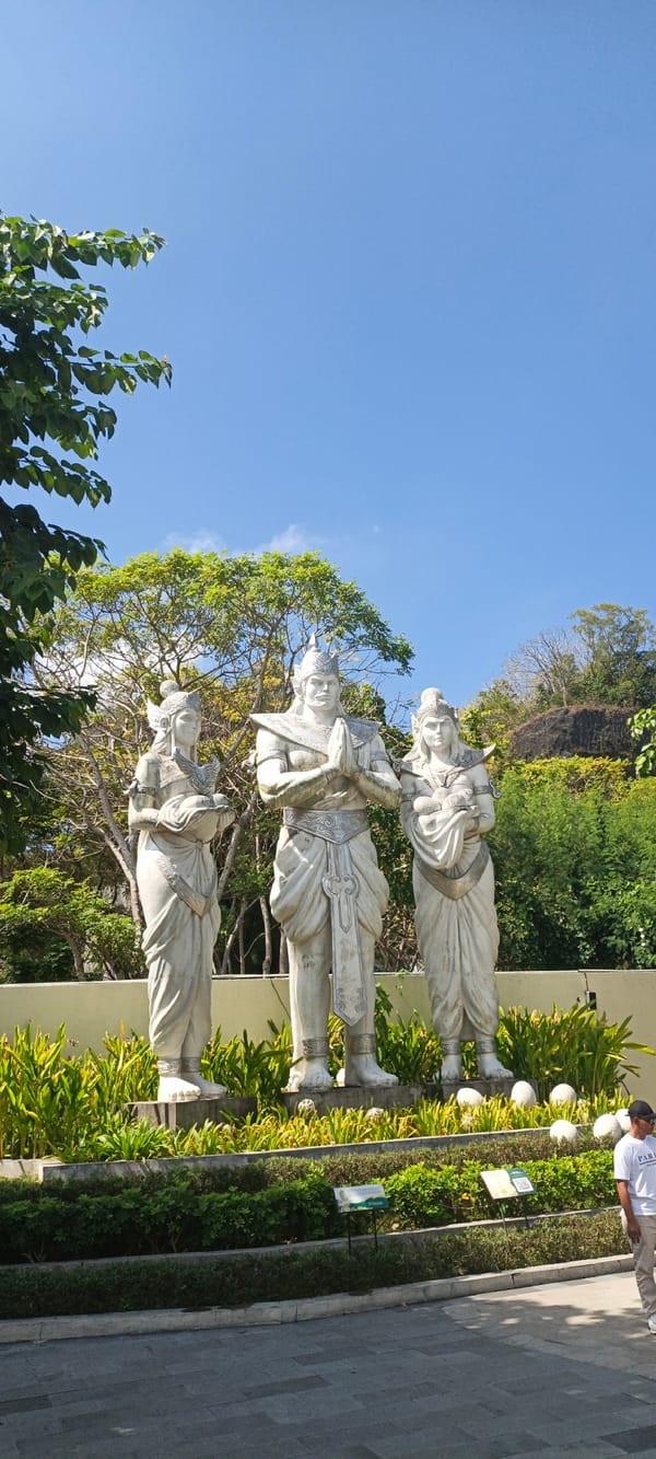 Three traditional white stone statues lined up in Kuta Selatan