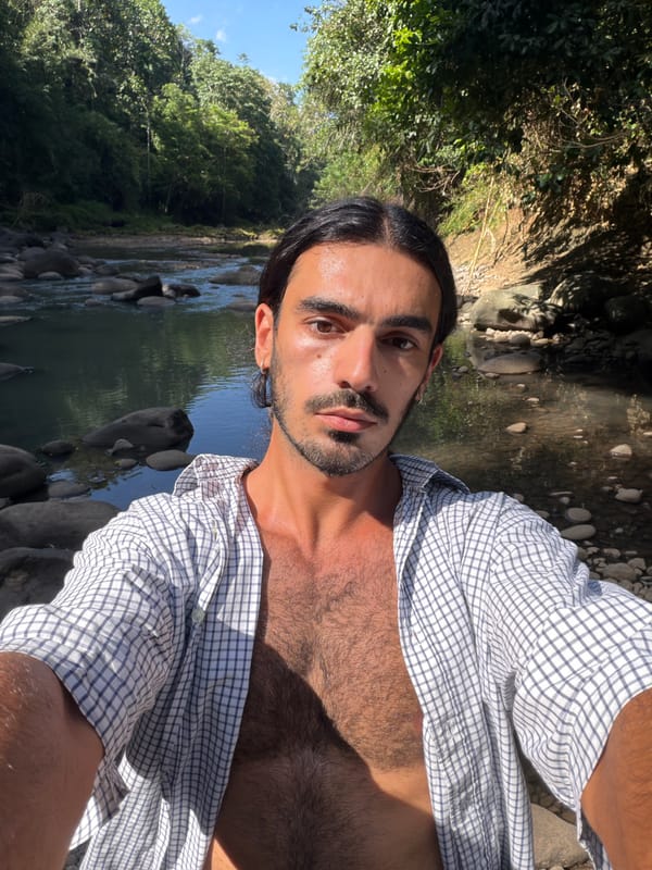 Man photographs riverside morning visit in Indonesian forest setting