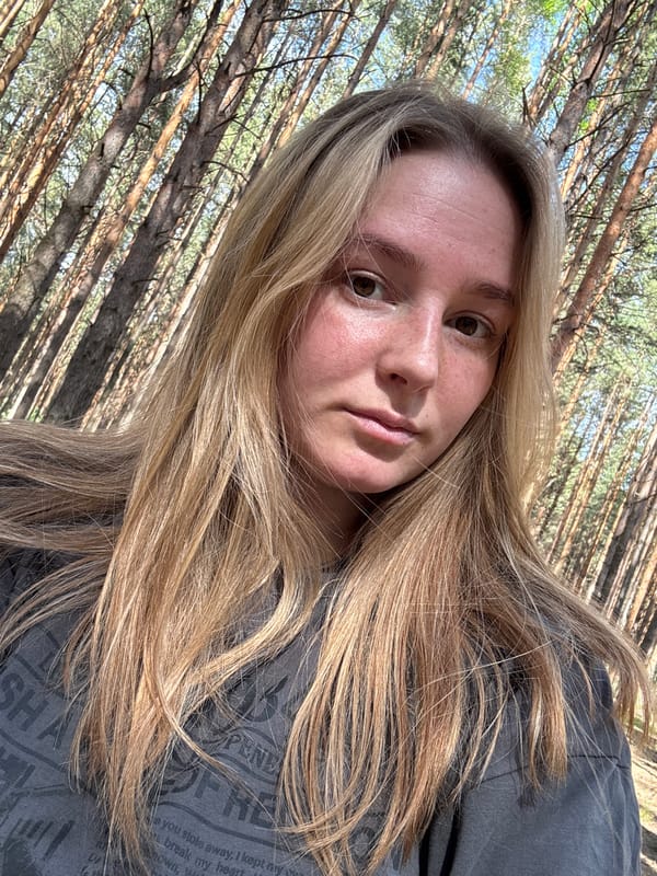 Woman takes forest selfie among tall trees