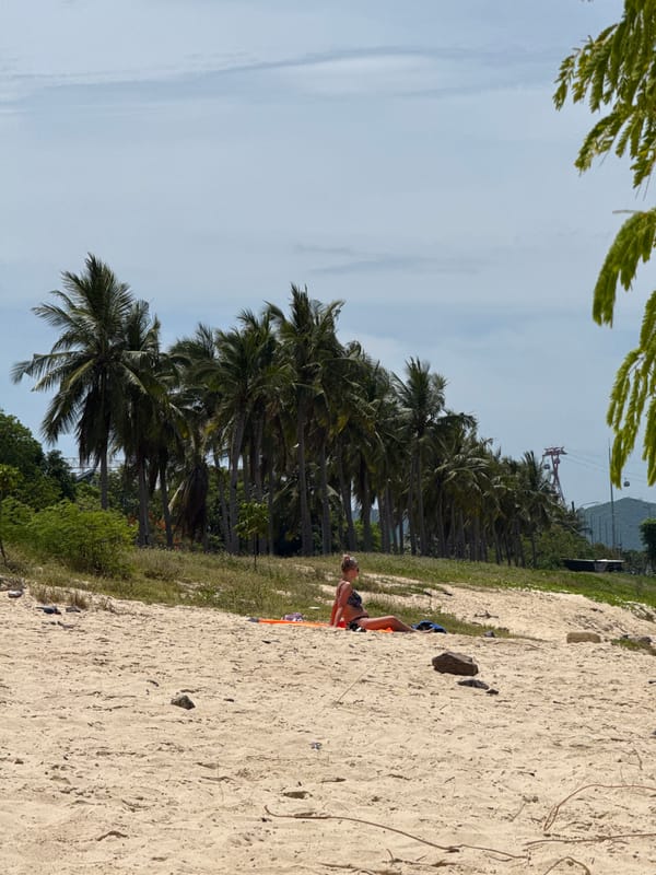 Nha Trang beach: sunbathers, swimmers, and a working dredge barge