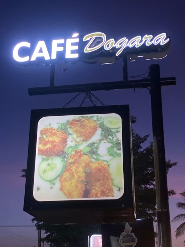 Neon café sign illuminated at night in Barden Yana