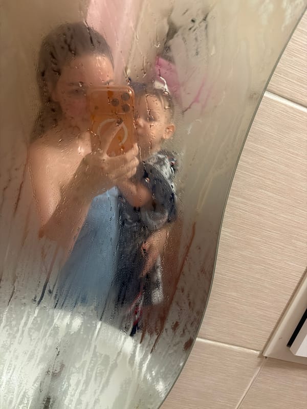 Selfie reflection captured through steamy shower door in Ufa