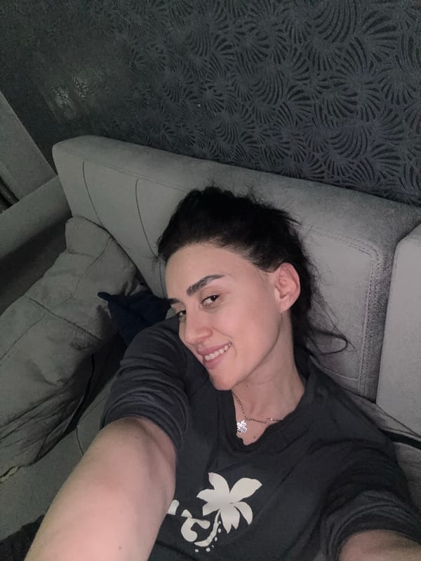 Woman rests on couch in Tbilisi home evening