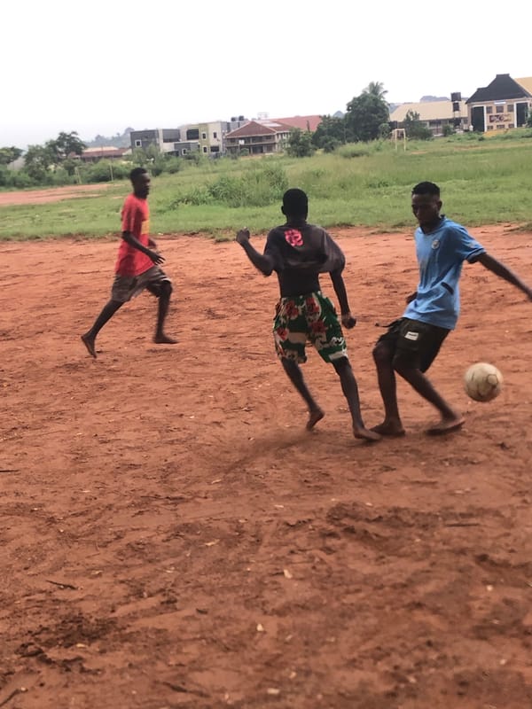 Nigerian youth play football, gather on dirt fields