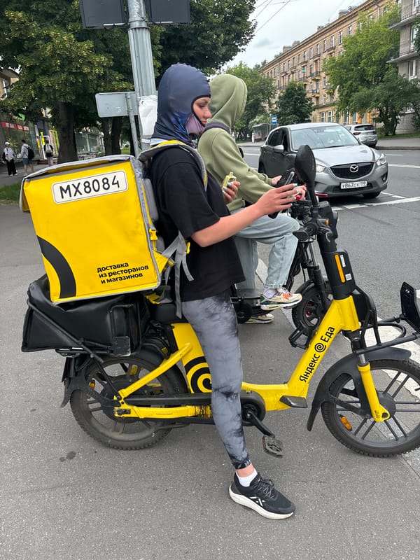 Selfies and a yellow delivery scooter in an outdoor setting