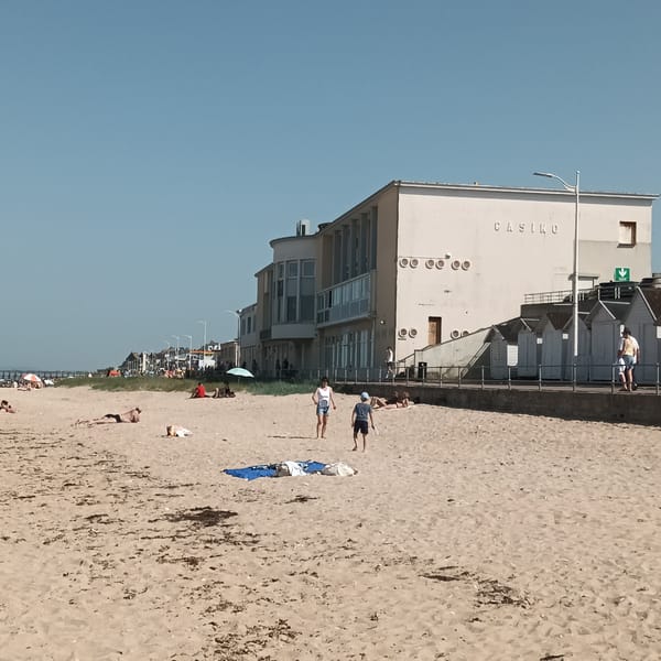 Beach day documented near casino with tennis, sailing activities
