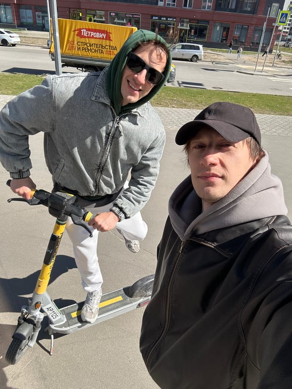 Two men take selfie while riding electric scooter in Murino