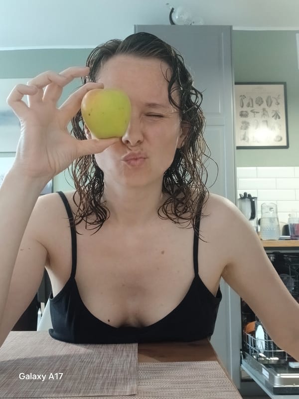 Woman poses with green apple in Yekaterinburg kitchen