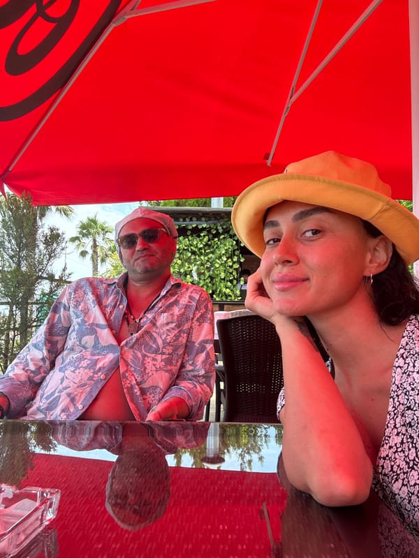 Café table photos under a red umbrella in Batumi