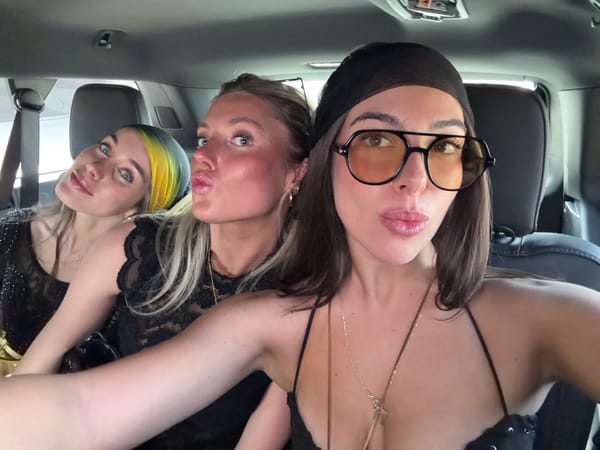 Three women gather close together inside vehicle in La Quinta