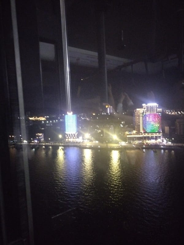 Nighttime cityscape reflection captured through window at undisclosed location
