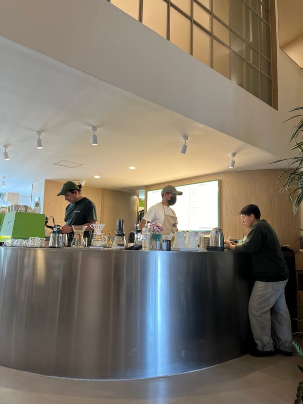 Three people behind steel counter at unknown business