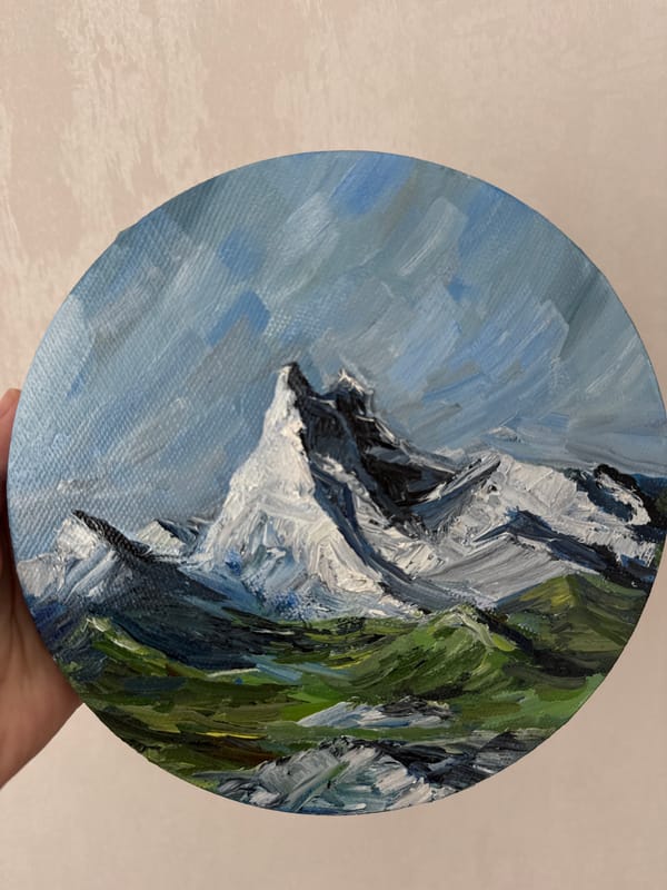Artist displays small mountain landscape painting in Krasnoyarsk home