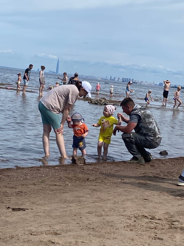Kids playing in Gulf of Finland shallows, Saint Petersburg summer morning