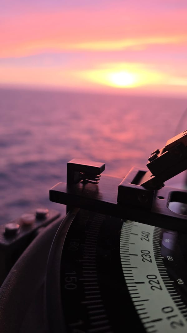 Ocean sunset documented from vessel with navigation instrument visible