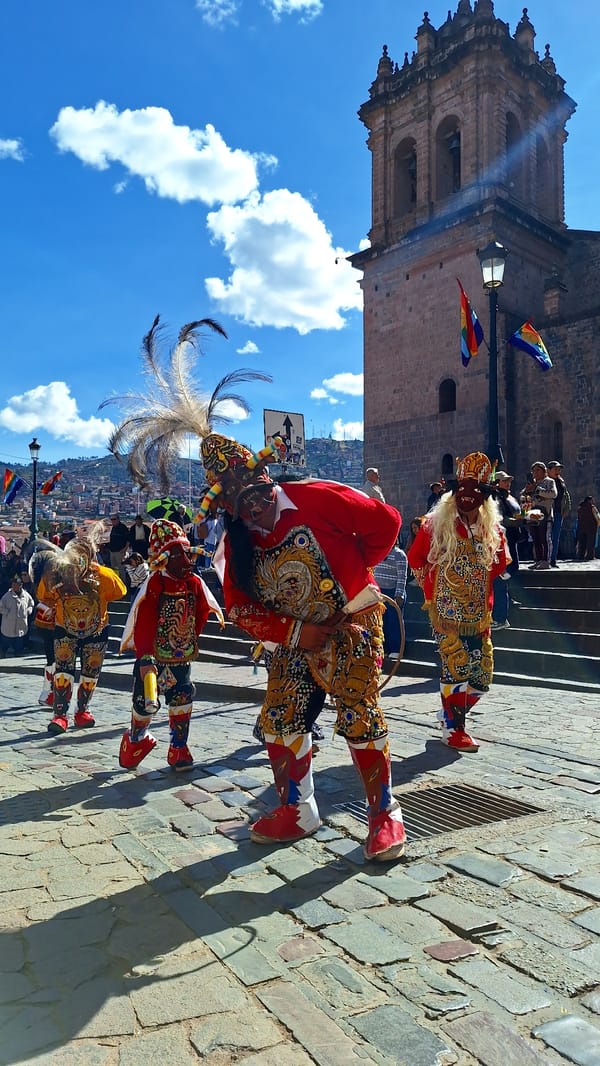 Traditional costumed performers gather on Cuzco cobblestone street