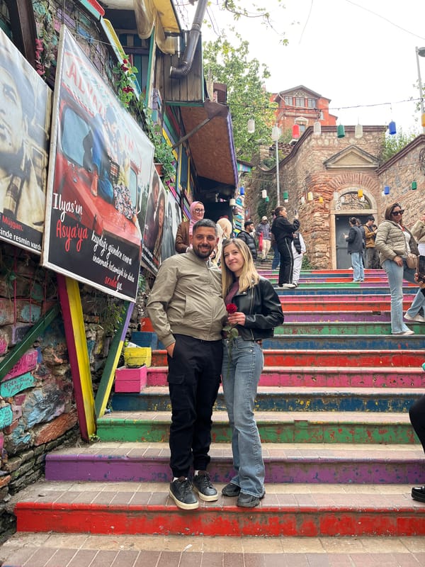 Couple poses on colorful stairs in historic Istanbul district