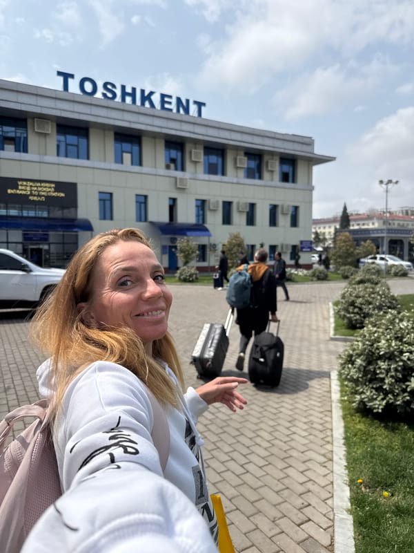 Woman photographs herself outside TOSHKENT building in Uzbekistan