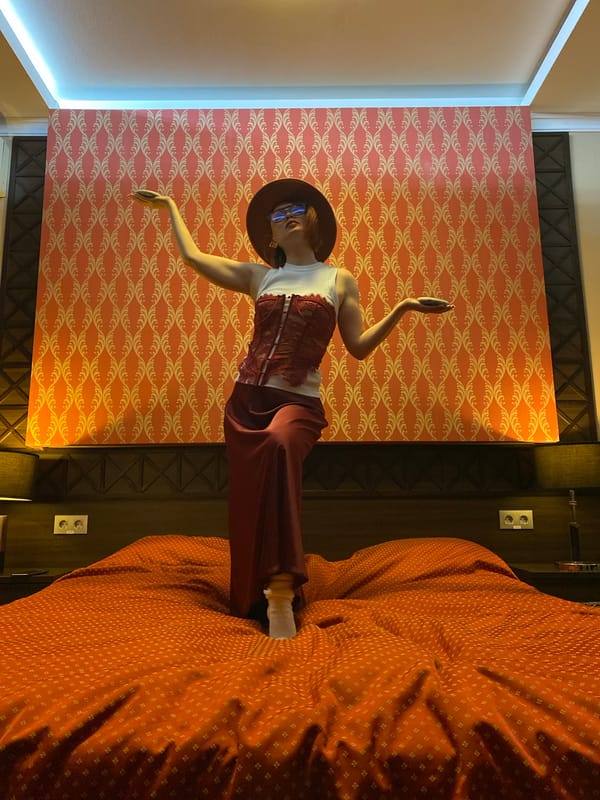 Person in colorful outfit poses in orange-themed room in Yekaterinburg