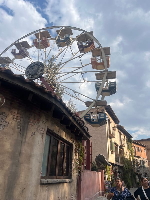 Ferris wheel operates near historic buildings in Domingo Arenas