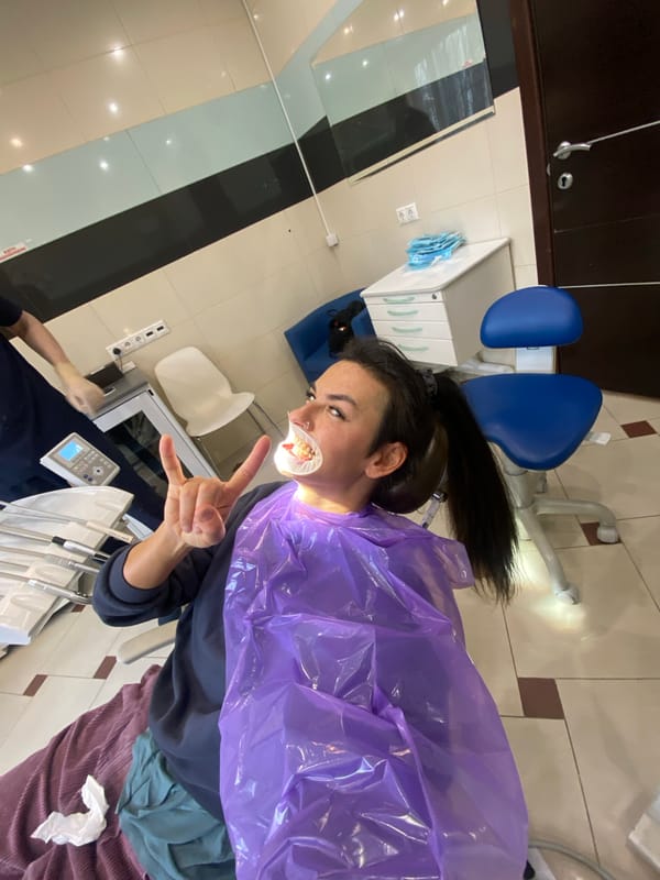 Patient makes rock gesture during dental procedure in Moscow