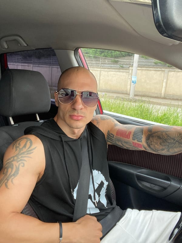 Man in aviator sunglasses photographed in car passenger seat