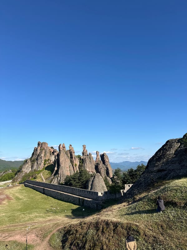 Tourist documents medieval fortress and rock formations in Bulgaria